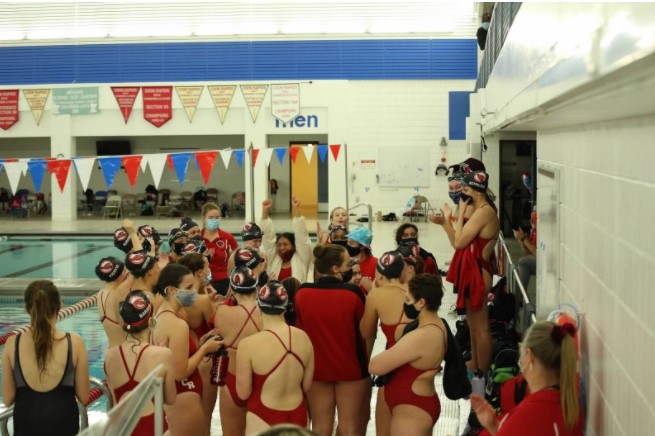 Coon Rapids Girls swim and dive team sport their masks on the pool deck after winning their second to the last meet against the Osseo Orioles. 